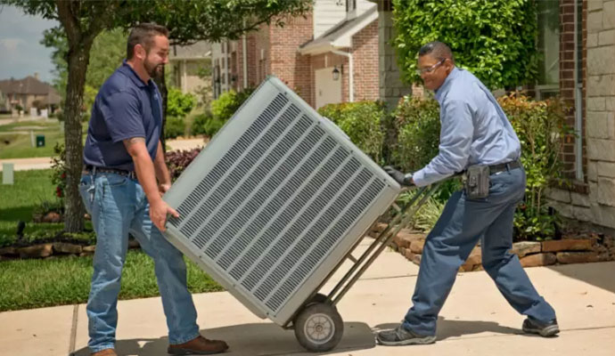 two individuals moving an AC