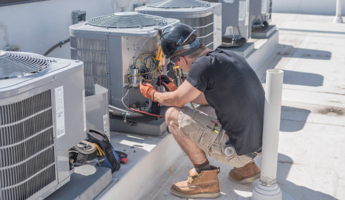 Person installing outdoor air conditioning unit