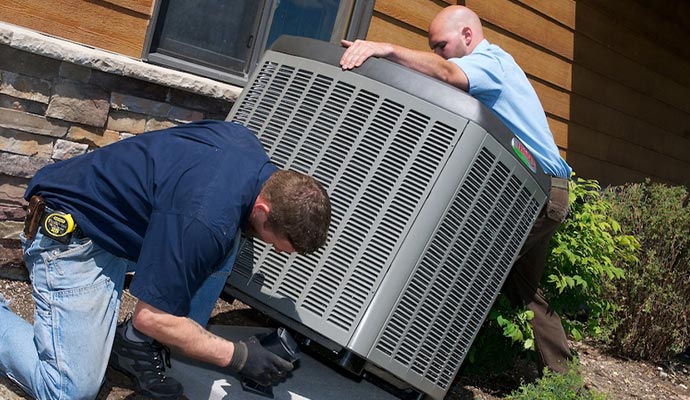 a couple of professionals installing a heat pump