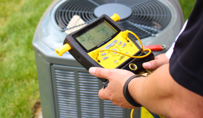 A person is performing HVAC system maintenance with equipment